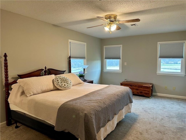 26609 S Red Bud Rd, Freeman, MO 64746 - carpeted bedroom featuring multiple windows, a ceiling fan, and a textured ceiling