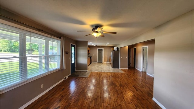 411 S Fulton St, Butler, MO 64730 - unfurnished living room featuring a ceiling fan and hardwood / wood-style floors
