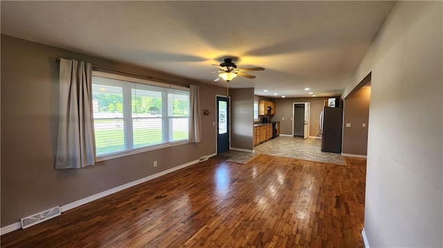 411 S Fulton St, Butler, MO 64730 - unfurnished living room featuring dark wood-type flooring, ceiling fan, and recessed lighting