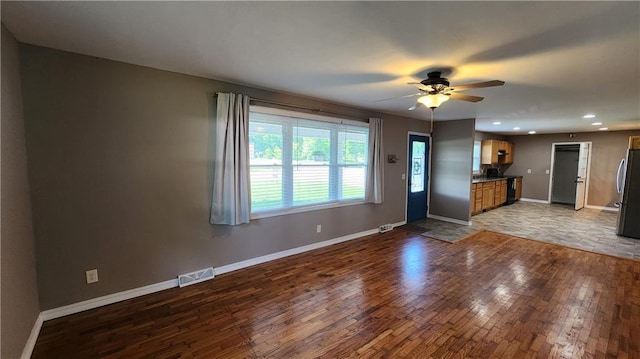 411 S Fulton St, Butler, MO 64730 - unfurnished living room with wood finished floors, ceiling fan, and recessed lighting