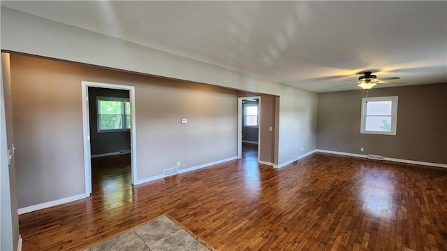 411 S Fulton St, Butler, MO 64730 - unfurnished room with dark wood finished floors, healthy amount of natural light, and a ceiling fan