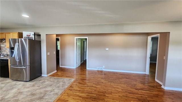 411 S Fulton St, Butler, MO 64730 - kitchen featuring stainless steel fridge with ice dispenser, dishwasher, light wood finished floors, light brown cabinets, and recessed lighting