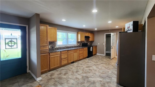 411 S Fulton St, Butler, MO 64730 - kitchen with freestanding refrigerator, black electric range oven, decorative backsplash, dark countertops, and recessed lighting
