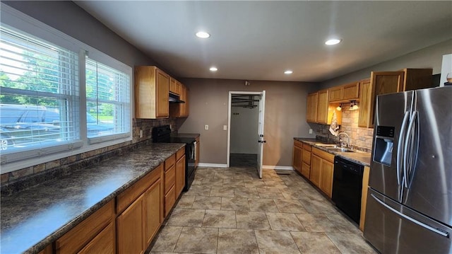 411 S Fulton St, Butler, MO 64730 - kitchen with black appliances, recessed lighting, decorative backsplash, under cabinet range hood, and dark countertops