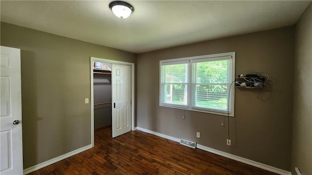 411 S Fulton St, Butler, MO 64730 - unfurnished bedroom featuring dark wood-style floors and a closet