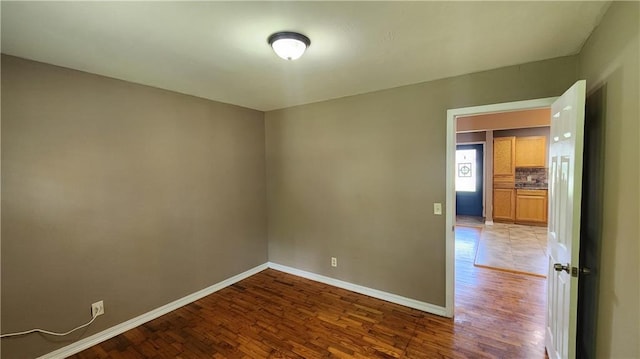 411 S Fulton St, Butler, MO 64730 - unfurnished room with wood finished floors and baseboards