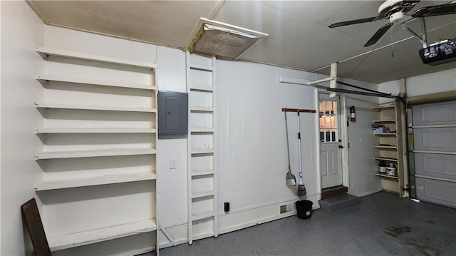 411 S Fulton St, Butler, MO 64730 - garage with electric panel, a ceiling fan, and a garage door opener