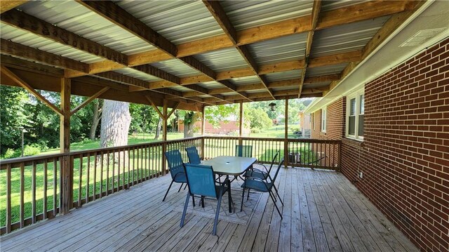 411 S Fulton St, Butler, MO 64730 - wooden deck with outdoor dining space and a lawn