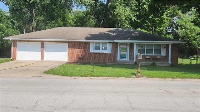 411 S Fulton St, Butler, MO 64730 - ranch-style home featuring a garage, driveway, a front lawn, and brick siding