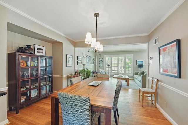 8604 Sagamore Rd, Leawood, KS 66206 - dining space featuring light wood-style floors, a chandelier, and ornamental molding