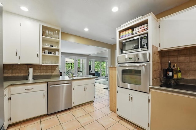 8604 Sagamore Rd, Leawood, KS 66206 - kitchen featuring stainless steel appliances, open shelves, white cabinetry, decorative backsplash, and recessed lighting