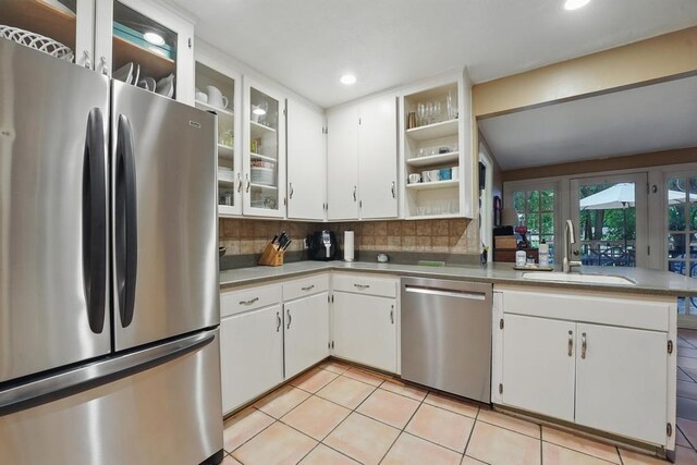 8604 Sagamore Rd, Leawood, KS 66206 - kitchen featuring stainless steel appliances, open shelves, backsplash, light tile patterned floors, and white cabinets