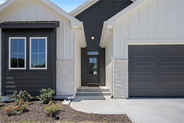 31501 W 86th Ct, De Soto, KS 66018 - doorway to property with board and batten siding, stone siding, and a garage