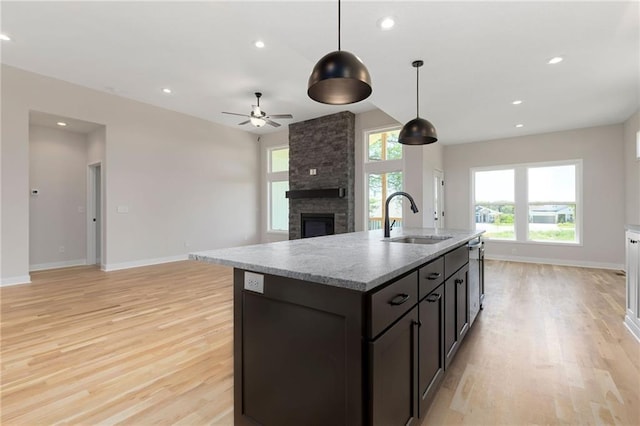31501 W 86th Ct, De Soto, KS 66018 - kitchen with light wood-style flooring, a fireplace, a ceiling fan, recessed lighting, and a kitchen island with sink