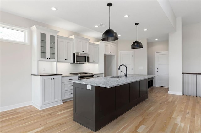 31501 W 86th Ct, De Soto, KS 66018 - kitchen featuring appliances with stainless steel finishes, white cabinetry, light wood-type flooring, a kitchen island with sink, and recessed lighting
