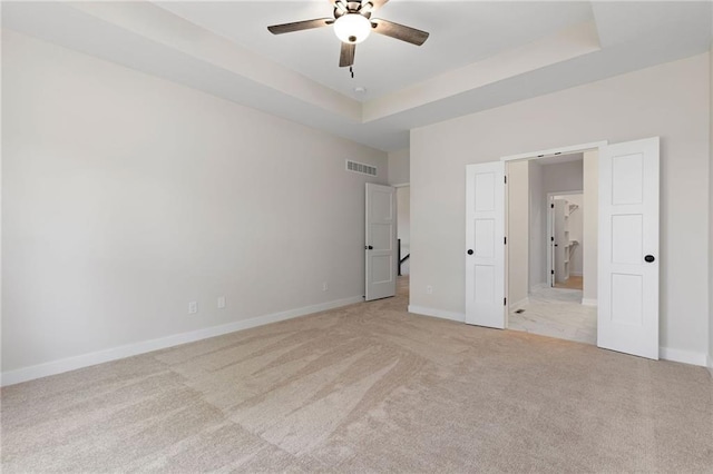 31501 W 86th Ct, De Soto, KS 66018 - unfurnished bedroom featuring light carpet, a tray ceiling, and ceiling fan