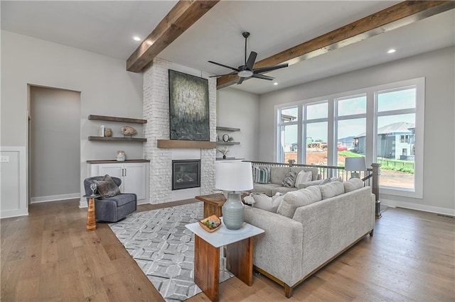 6113 Barth Rd, Shawnee, KS 66226 - living room featuring beamed ceiling, ceiling fan, wood finished floors, baseboards, and a fireplace