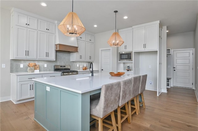 6113 Barth Rd, Shawnee, KS 66226 - kitchen with appliances with stainless steel finishes, wood finished floors, backsplash, light countertops, and baseboards