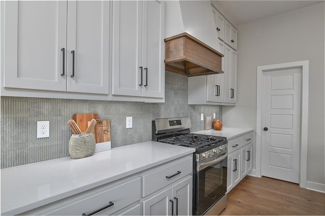 6113 Barth Rd, Shawnee, KS 66226 - kitchen with stainless steel range with gas cooktop, light countertops, white cabinetry, and wood finished floors