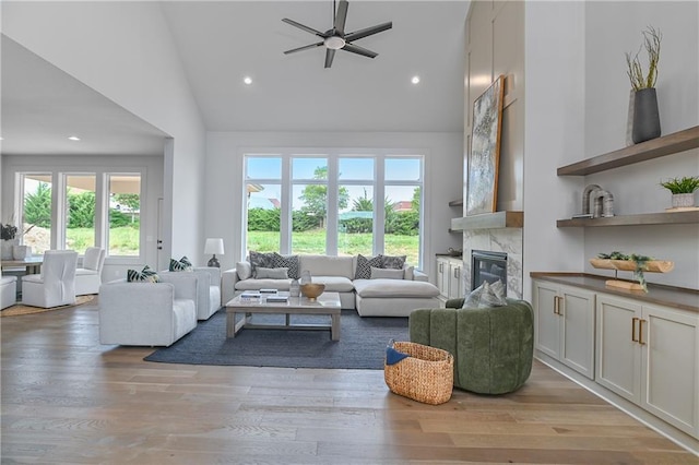 6039 Apache Dr, Shawnee, KS 66226 - living room featuring healthy amount of natural light, a high end fireplace, a ceiling fan, light wood-type flooring, and high vaulted ceiling