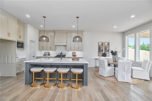 6039 Apache Dr, Shawnee, KS 66226 - kitchen with premium range hood, light countertops, backsplash, built in microwave, and light wood-style flooring