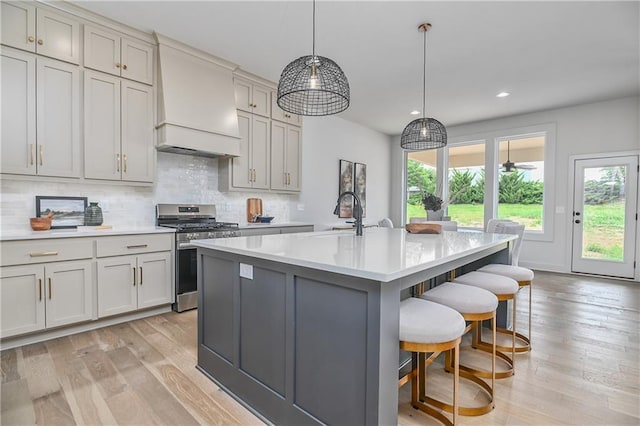 6039 Apache Dr, Shawnee, KS 66226 - kitchen featuring stainless steel gas range, premium range hood, healthy amount of natural light, light countertops, and recessed lighting