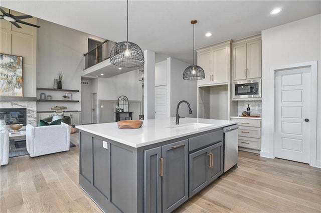 6039 Apache Dr, Shawnee, KS 66226 - kitchen featuring a sink, gray cabinets, appliances with stainless steel finishes, open floor plan, and light wood-style flooring