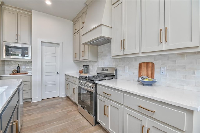 6039 Apache Dr, Shawnee, KS 66226 - kitchen with custom exhaust hood, appliances with stainless steel finishes, light countertops, and recessed lighting