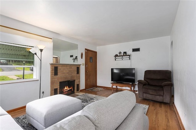 3131 E Barker Cir, Kansas City, KS 66104 - living room with a brick fireplace, wood finished floors, and baseboards
