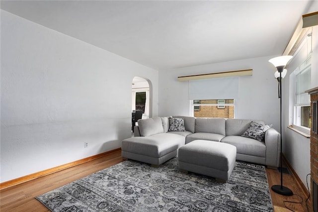 3131 E Barker Cir, Kansas City, KS 66104 - living room with arched walkways, healthy amount of natural light, wood finished floors, and baseboards