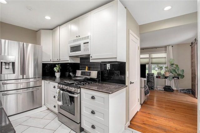 1307 W 30th St S, Independence, MO 64052 - kitchen with appliances with stainless steel finishes, tasteful backsplash, white cabinetry, recessed lighting, and dark stone countertops