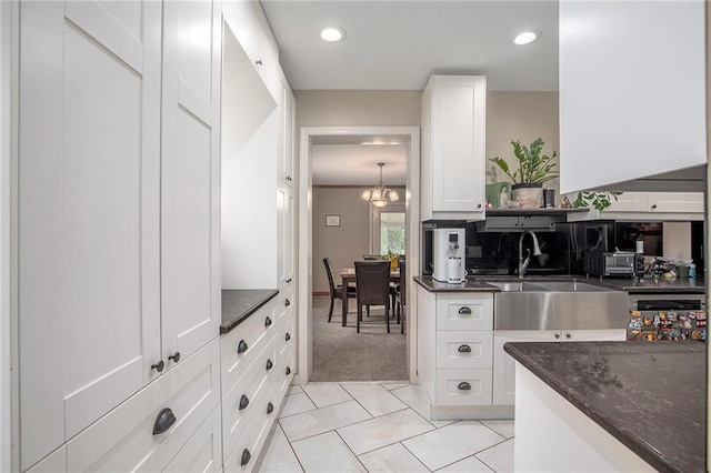1307 W 30th St S, Independence, MO 64052 - kitchen featuring a sink, dark stone countertops, white cabinetry, a chandelier, and light tile patterned floors