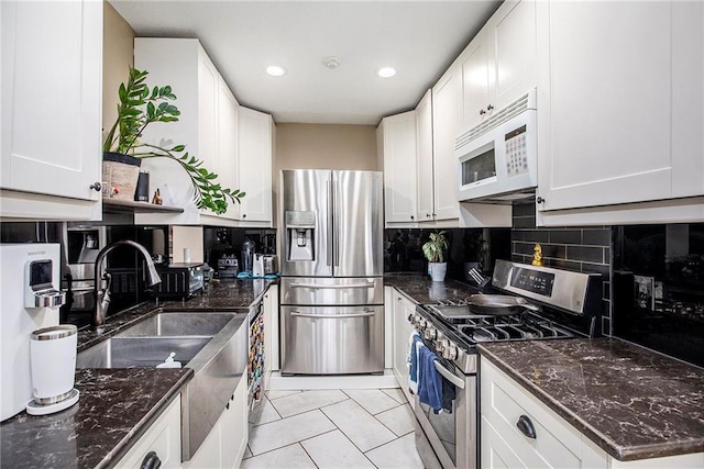 1307 W 30th St S, Independence, MO 64052 - kitchen featuring appliances with stainless steel finishes, tasteful backsplash, white cabinetry, dark stone counters, and recessed lighting