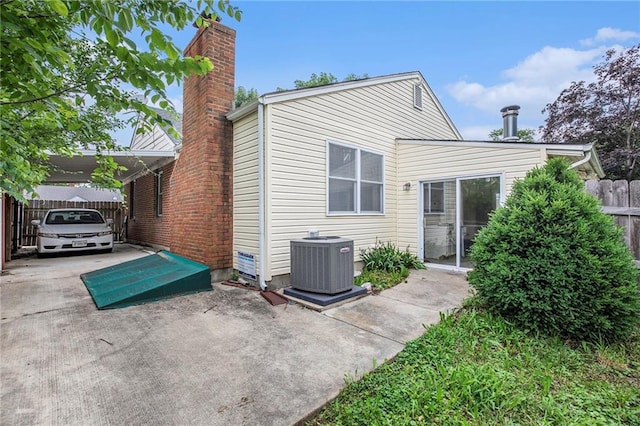 1307 W 30th St S, Independence, MO 64052 - back of property with cooling unit, a chimney, and an attached carport