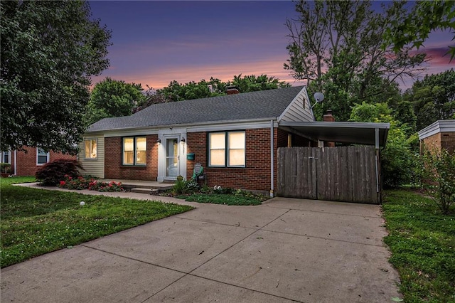 1307 W 30th St S, Independence, MO 64052 - view of front of property featuring brick siding, driveway, a yard, a carport, and a shingled roof