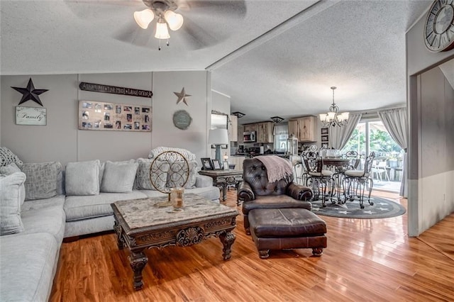 31965 Lakecrest Dr, Excelsior Springs, MO 64024 - living room with a textured ceiling, a ceiling fan, light wood-style floors, and a chandelier