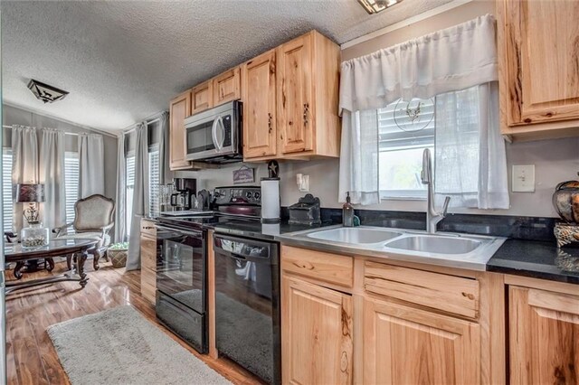 31965 Lakecrest Dr, Excelsior Springs, MO 64024 - kitchen with black appliances, light brown cabinets, a textured ceiling, light wood-style floors, and dark countertops