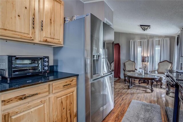 31965 Lakecrest Dr, Excelsior Springs, MO 64024 - kitchen featuring stainless steel refrigerator with ice dispenser, light brown cabinets, wood finished floors, a textured ceiling, and dark stone countertops