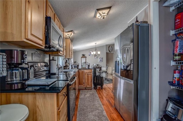 31965 Lakecrest Dr, Excelsior Springs, MO 64024 - kitchen featuring fridge with ice dispenser, stainless steel microwave, black range with electric cooktop, a textured ceiling, and a chandelier