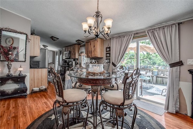 31965 Lakecrest Dr, Excelsior Springs, MO 64024 - dining room featuring a textured ceiling, a chandelier, and wood finished floors