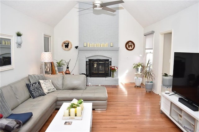 7833 Garnett St, Lenexa, KS 66214 - living room with vaulted ceiling, a ceiling fan, light wood-style flooring, and a fireplace