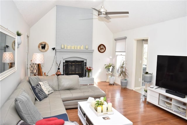 7833 Garnett St, Lenexa, KS 66214 - living area featuring lofted ceiling, a ceiling fan, a fireplace, and wood finished floors