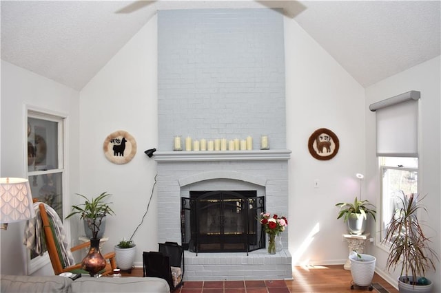 7833 Garnett St, Lenexa, KS 66214 - living room featuring a fireplace, baseboards, wood finished floors, and high vaulted ceiling