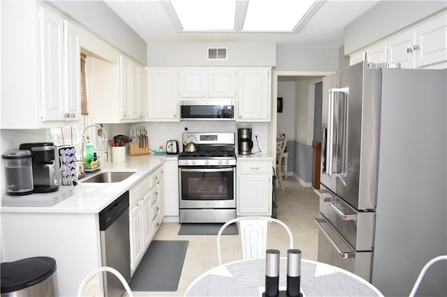 7833 Garnett St, Lenexa, KS 66214 - kitchen with appliances with stainless steel finishes, a sink, light countertops, and white cabinetry