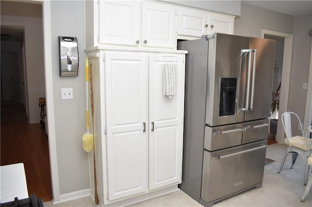 7833 Garnett St, Lenexa, KS 66214 - kitchen featuring stainless steel fridge with ice dispenser, white cabinets, and baseboards