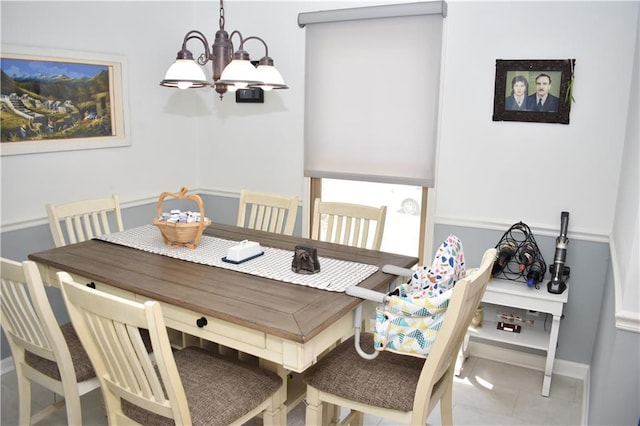 7833 Garnett St, Lenexa, KS 66214 - dining space featuring a chandelier, baseboards, and tile patterned flooring