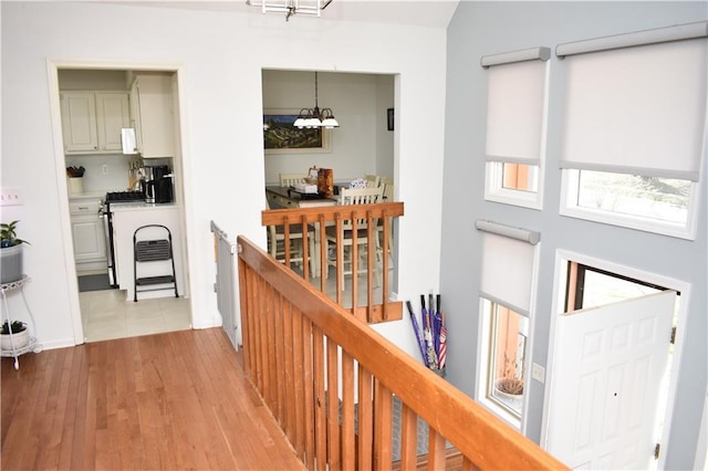 7833 Garnett St, Lenexa, KS 66214 - corridor with an upstairs landing, a chandelier, and light wood-style flooring