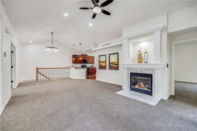 812 E 110th Ter, Kansas City, MO 64131 - unfurnished living room featuring carpet floors, a ceiling fan, lofted ceiling, a high end fireplace, and a chandelier