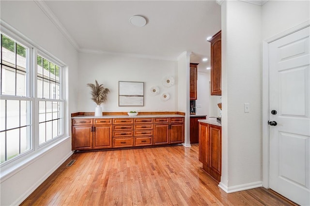 812 E 110th Ter, Kansas City, MO 64131 - kitchen featuring brown cabinets, light wood-style flooring, ornamental molding, and light countertops
