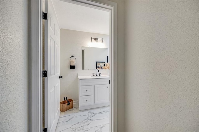812 E 110th Ter, Kansas City, MO 64131 - bathroom with a textured wall, marble look tiles, and vanity